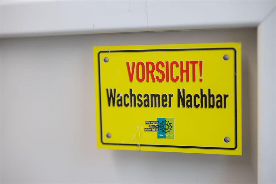 Ein Aufkleber mit der Aufschrift „Vorsicht! Wachsamer Nachbar“ klebt an einer Fensterscheibe.Christoph Reichwein/dpa