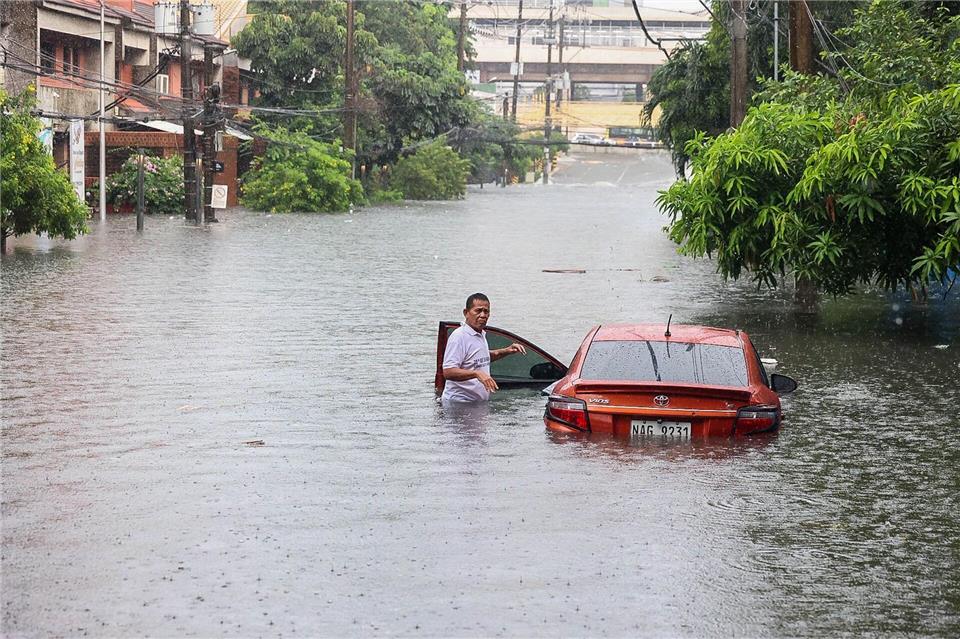 Ein Auto steht während eines starken Regens mit Überschwemmungen in Quezon City im tiefen Wasser.Rouelle Umali/XinHua/dpa