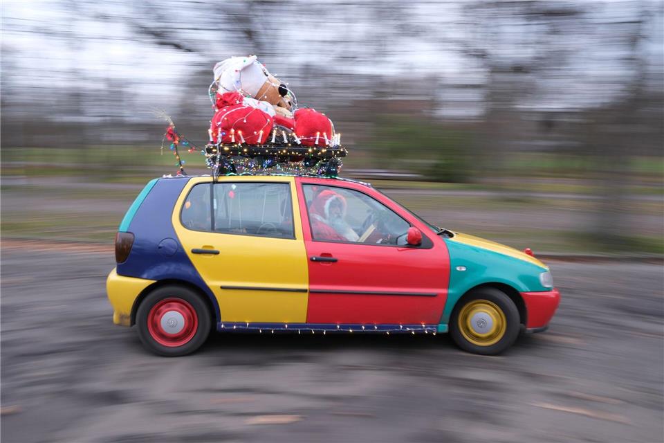 Ein Auto vom Typ Volkswagen Polo in der Edition Harlekin aus dem Jahr 1996 fährt weihnachtlich dekoriert durch Leipzig. Sebastian Willnow/dpa