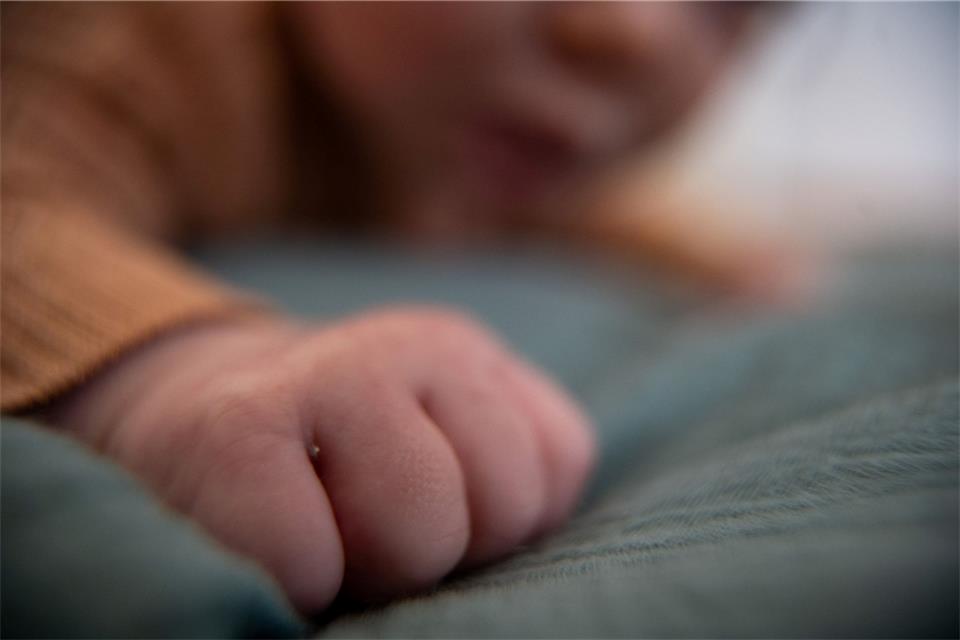 Ein Baby liegt auf einem Tuch.