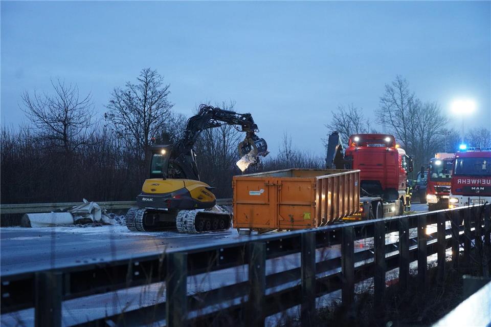 Ein Bagger räumt Trümmerteile nach einer Unfallserie bei Glätte mit mehreren Toten und vielen Verletzten auf der A44 von der Fahrbahn.Christian Müller/dpa