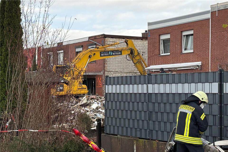 Ein Bagger räumt den Schutt eines eingestürzten Reihenhauses in Wolfenbüttel fort. In den Trümmern ist eine Leiche entdeckt worden. Benjamin Müller/dpa