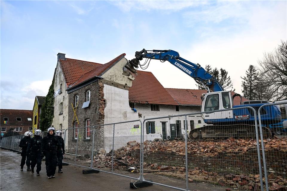 Ein Bagger reißt eine Wand an dem ehemaligen Bauernhof von Eckardt Heukamp, genannt „der letzte Bauer von Lützerath“, ein.