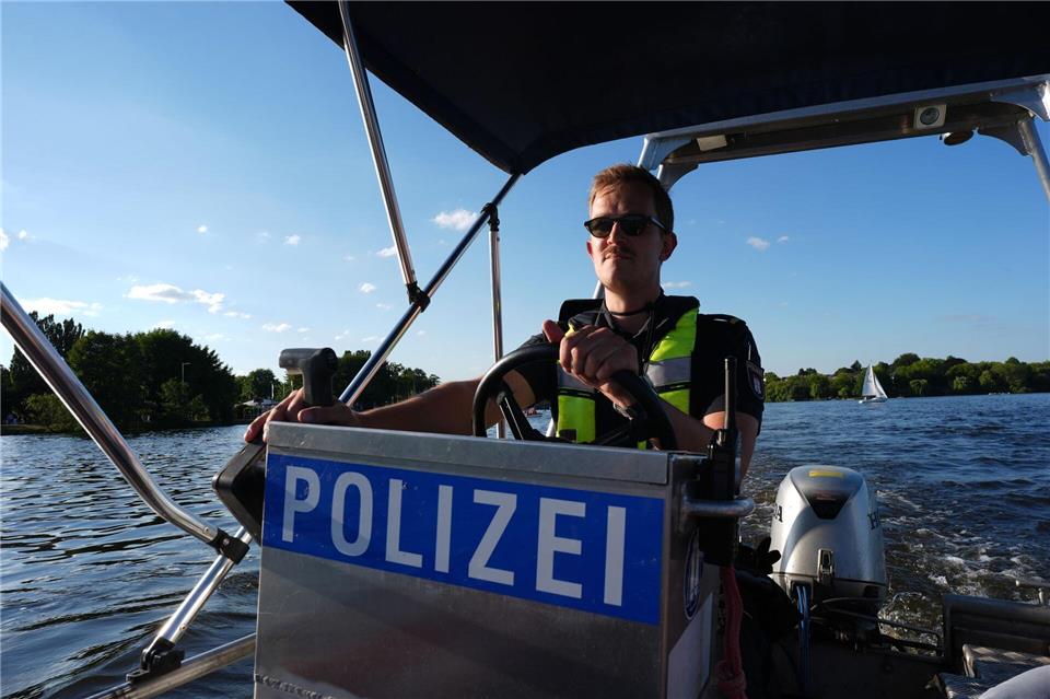 Ein Beamter steuert ein Polizeiboot mit Benzinmotor über die Alster.Marcus Brandt/dpa