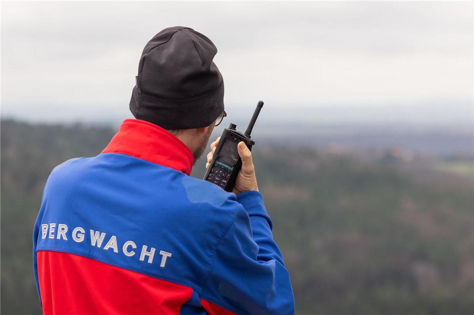 Ein Bergretter spricht während einer Übung der Bergwacht des Deutschen Roten Kreuzes (DRK) Dresden am Rauenstein in der Sächsischen Schweiz in sein Funkgerät. Jürgen Lösel/dpa