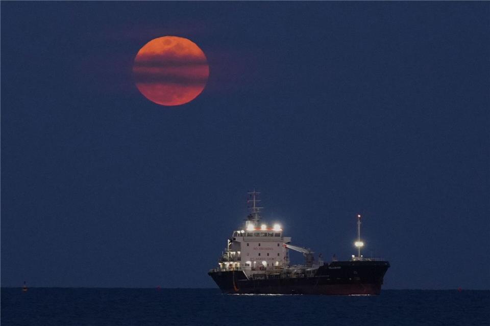 Ein Blutmond geht über dem Mittelmeer bei Limassol auf, wo ein Schiff vor Anker liegt.Petros Karadjias/AP/dpa