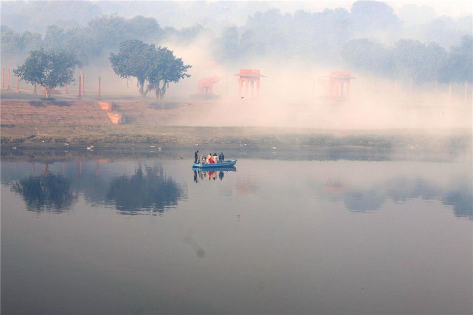 Ein Boot fährt bei Nebel auf dem Yamuna-Fluss.Deepak/ZUMA Press Wire/dpa