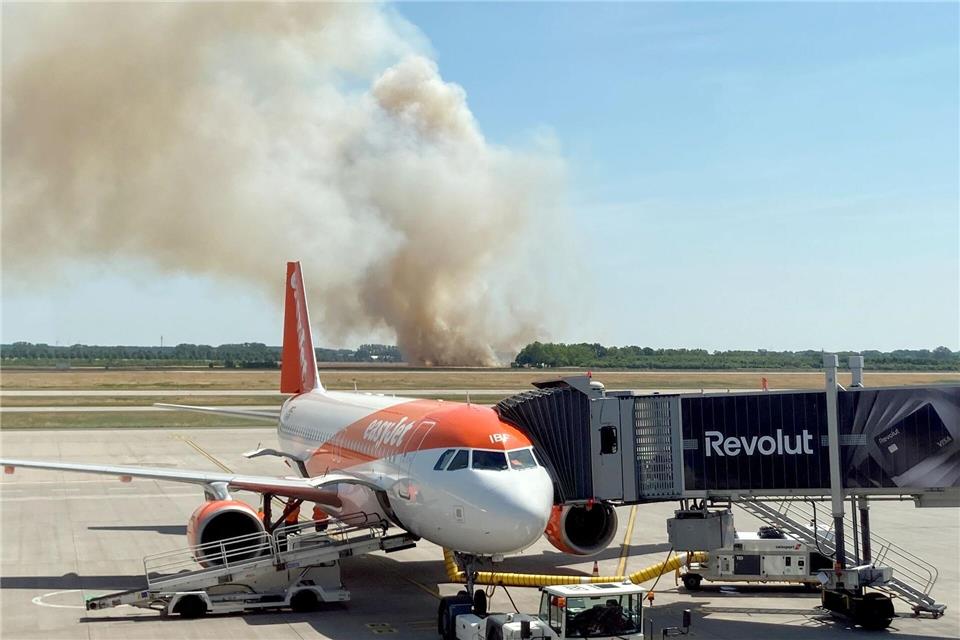 Ein Brand auf einem Getreidefeld ganz in der Nähe des Flughafens BER erzeugt auch bei Fluggästen Aufmerksamkeit. Tobias Schmidt/dpa
