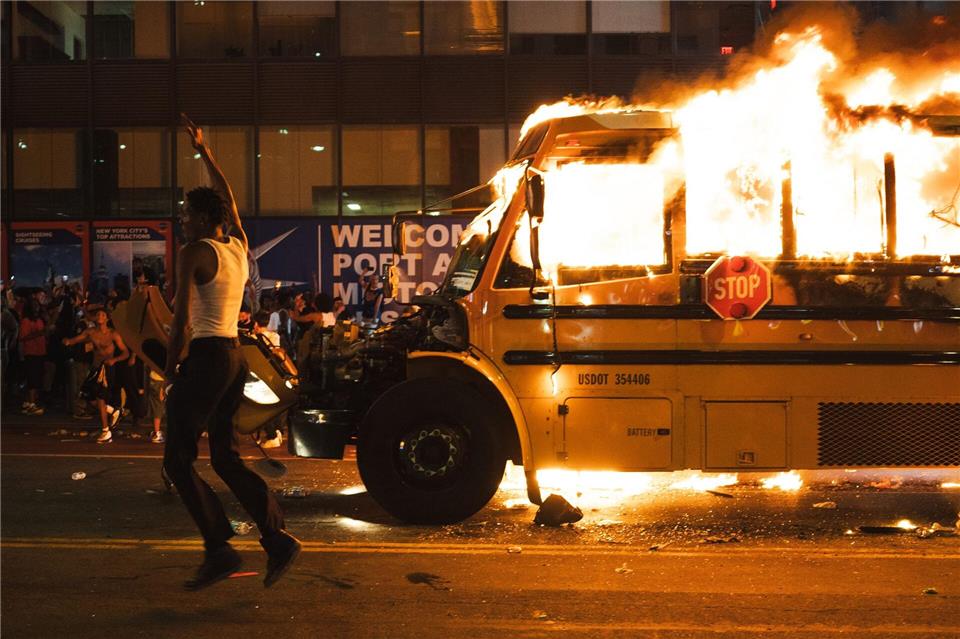 Ein Bus wird in Brand gesteckt.Derek French/ZUMA Press Wire/dpa