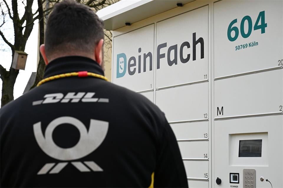 Ein DHL-Paketbote holt Sendungen aus einem DeinFach-Automaten.Wolf von Dewitz/dpa