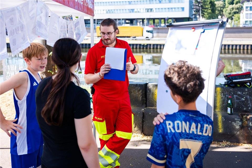 Ein DLRG-Ausbilder erklärt Schülerinnen und Schüler aus Saarbrücken Gefahren am Wasser und die richtigen Verhaltensweisen im Notfall.Laszlo Pinter/dpa