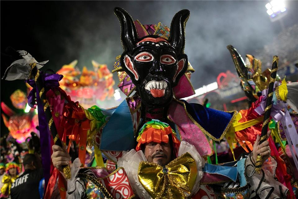 Ein Darsteller der Sambaschule Beija Flor zieht während der Karnevalsfeierlichkeiten im Sambadrom durch die Straßen.Bruna Prado/AP/dpa