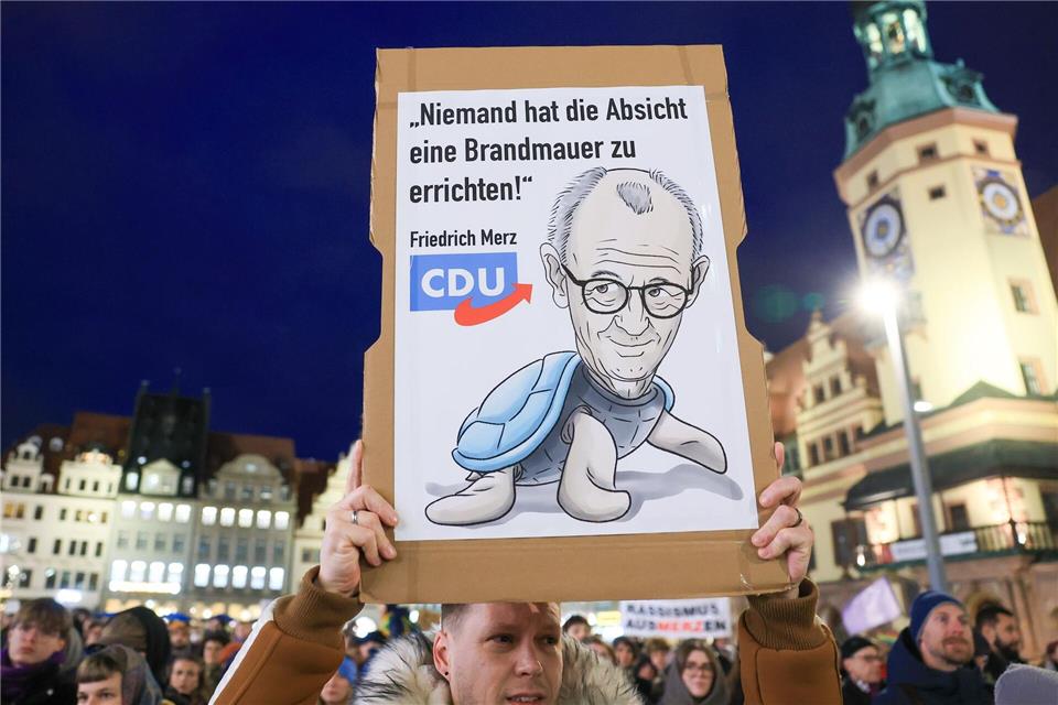 Hunderte demonstrieren in Leipzig nach „Stadtbild“-Aussage  Ein Demo-Teilnehmer hält ein Plakat mit der Aufschrift „Niemand hat die Absicht eine Brandmauer zu errichten“ hoch.Jan Woitas/dpa
