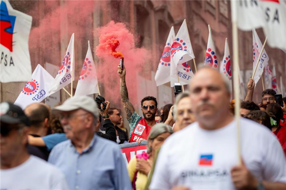 Ein Demonstrant hebt eine rote Fackel während eines eintägigen Generalstreiks und Protests in Porto gegen die geplante Arbeitsmarktreform der konservativen Regierung in Portugal.Diogo Baptista/SOPA Images via ZUMA Press Wire/dpa