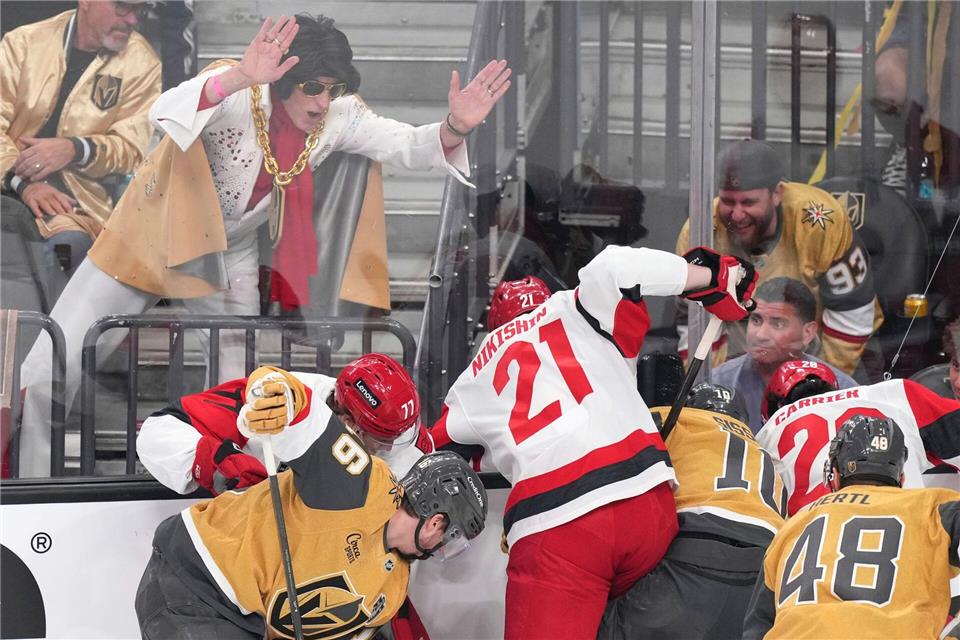 Ein Elvis-Imitator schlägt auf die Scheibe, während die Spieler um den Puck kämpfen.Candice Ward/AP/dpa