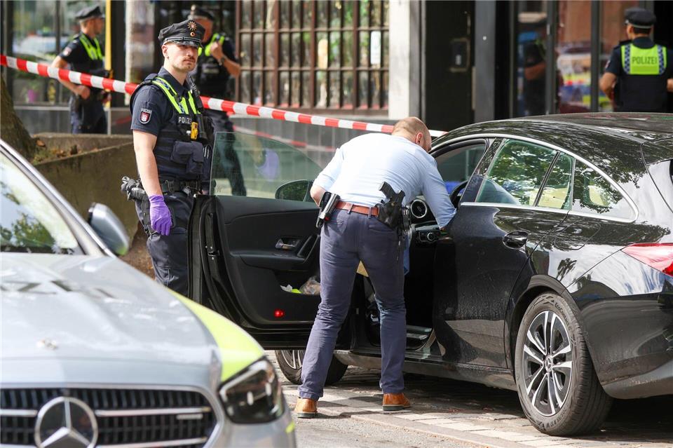 Bilder des Tages Ein Ermittler durchsucht ein abgestelltes Fahrzeug vor einer Shisha-Bar in Hamburg, in der am Morgen eine tote Person gefunden wurde.Bodo Marks/dpa