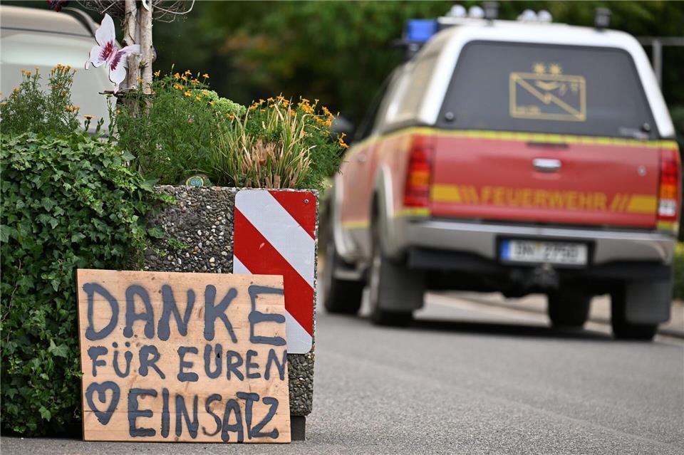 Ein Fahrzeug der Feuerwehr fährt an einem Schild mit der Aufschrift „Danke für Euren Einsatz“ beim Waldbrand im Hürtgenwald vorbei. Federico Gambarini/dpa