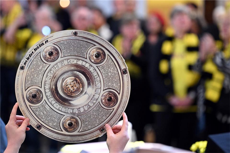 Sonnige BVB-Meisterfeier möglich? Mildes Pfingstwochenende Ein Fan hält beim Gottesdienst in der Gründungskirche des BVB eine Meisterschale in die Höhe.