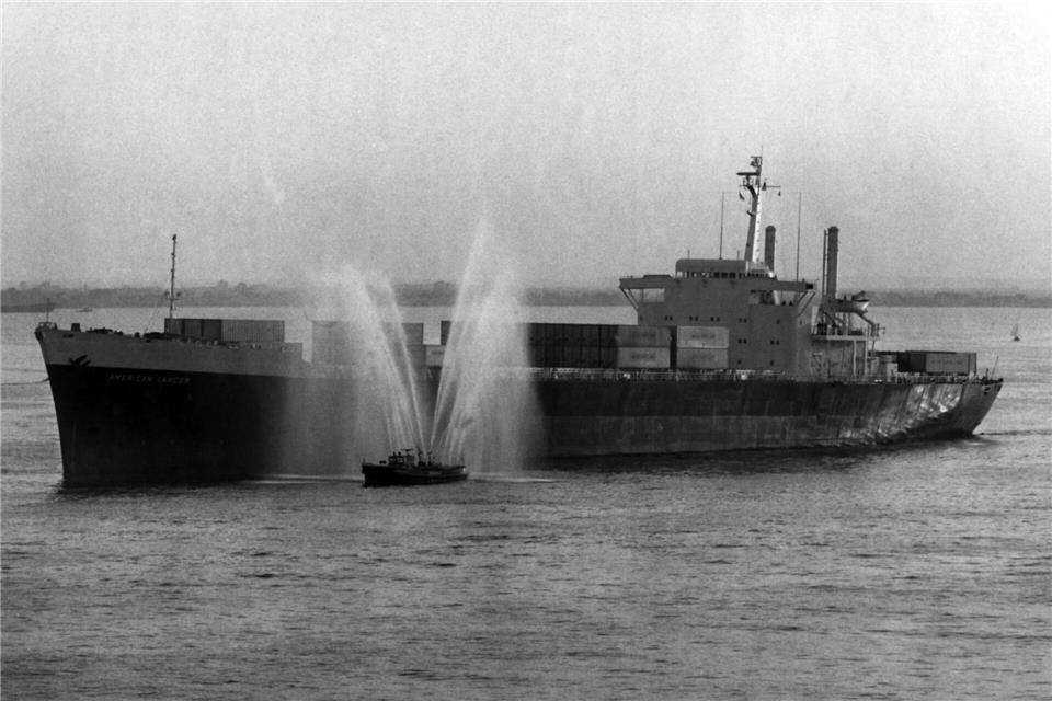 Ein Feuerlöschboot begrüßt 1968 die „American Lancer“, das erste Vollcontainerschiff in Hamburg. (Archivbild) dpa
