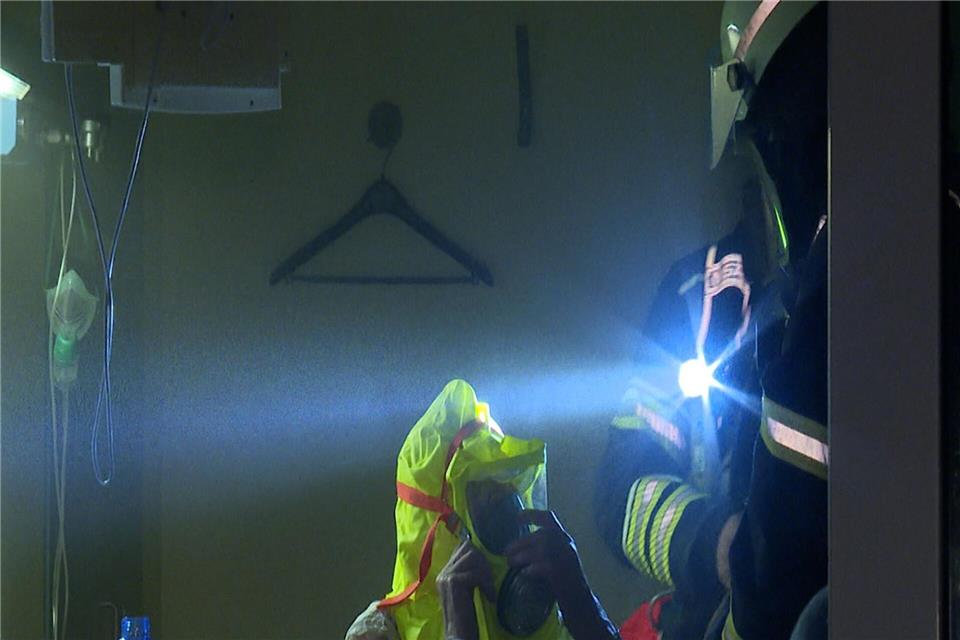 Ein Feuerwehrmann hilft einem Patienten in einem Zimmer des Krankenhauses.Steven Hutchings/dpa