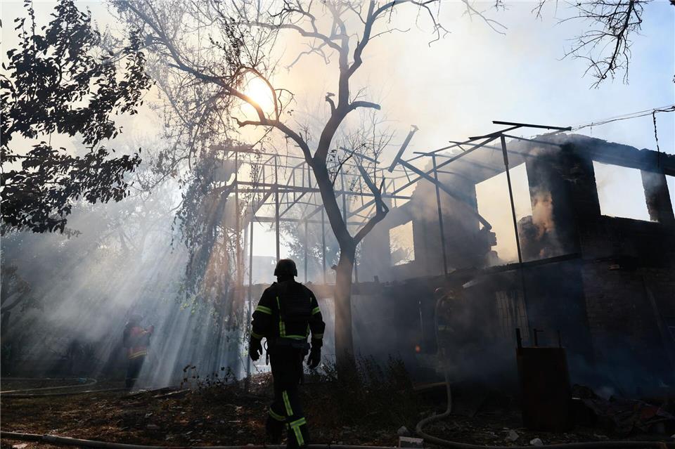 Ein Feuerwehrmann ist im Einsatz, nachdem eine russische Bombe ein Haus im ukrainischen Saporischschja getroffen hat.Kateryna Klochko/AP/dpa