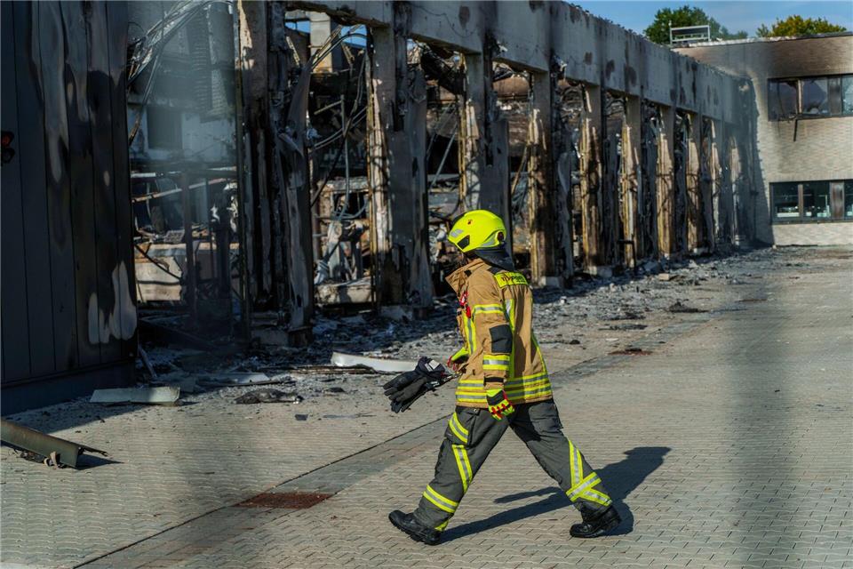 Feuerwache brennt - „Wir mussten unser Zuhause löschen“ Ein Feuerwehrmann ist vor dem ausgebrannten Gerätehaus der Feuerwache Stadtallendorf unterwegs, in der am frühen Morgen ein Brand gewütet hat. (Foto aktuell)Andreas Arnold/dpa