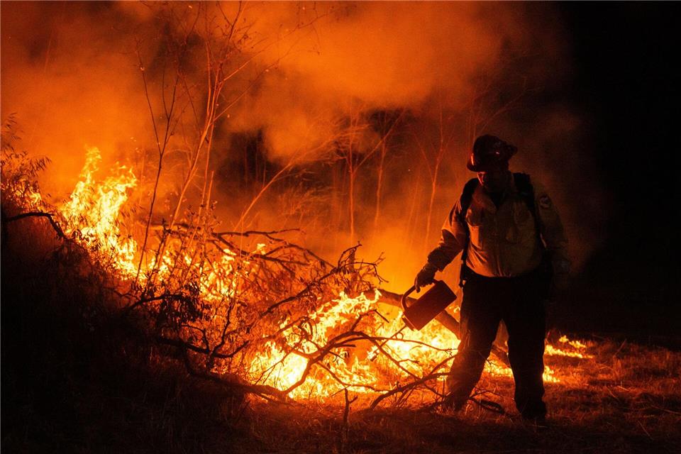 Ein Feuerwehrmann kämpft gegen die FlammenEthan Swope/AP/dpa