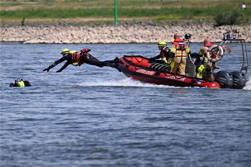 Ein Feuerwehrmann springt bei einer Übung von einem Boot in den Rhein, um eine Puppe zu „retten“. (Archivbild)Federico Gambarini/dpa