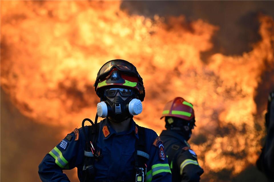 Ein Feuerwehrmann steht vor den lodernden Flammen nordwestlich von Athen.Michael Varaklas/AP/dpa