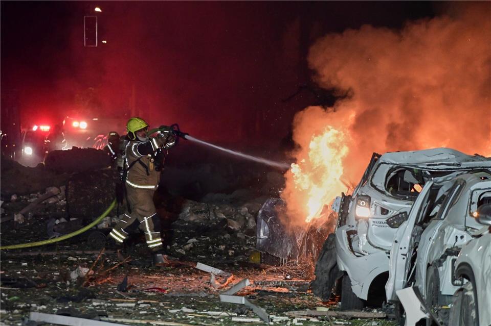 Ein Feuerwehrmann versucht, ein brennendes Auto zu löschen.Tomer Neuberg/AP/dpa