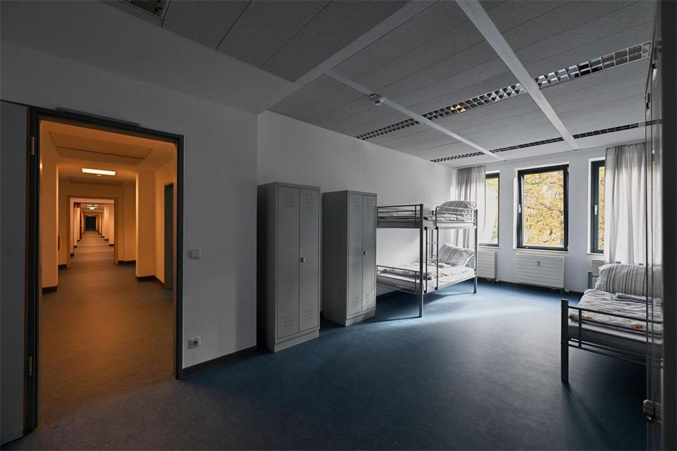 Ein Gemeinschaftszimmer mit drei Betten, aufgenommen in der neuen Unterkunft für geflüchtete Menschen in einem ehemaligen Bürogebäude in der Hasenheide.Soeren Stache/dpa