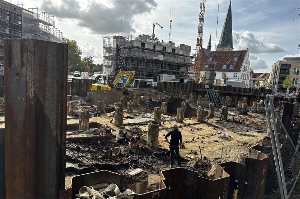 Ein Grabungsteam (vorne links) erkundet derzeit den Bereich der künftigen Tiefgarage. Bei den regelmäßig angeordneten Pfeilern handelt es sich nicht um historische Überbleibsel, sondern um Betonpfähle, die das künftige Gebäude an der Borkener Aa stabilisieren sollen. 