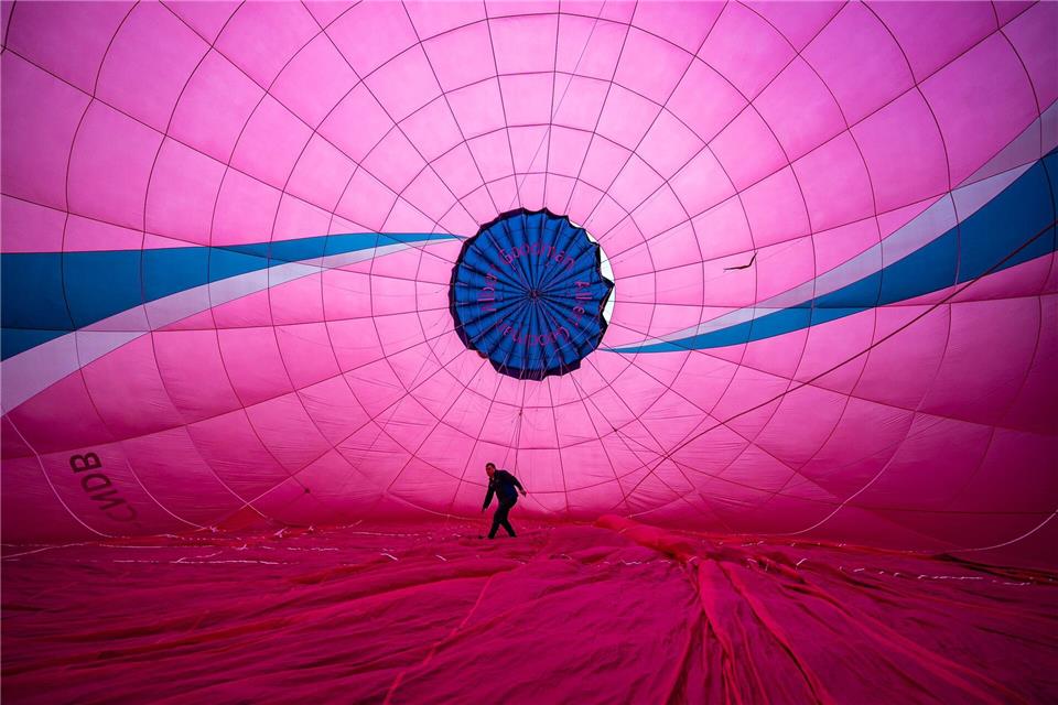 Ein Heißluftballonpilot prüft die Innenverankerung der Ballonhülle. Die jährliche Bristol Balloon Fiesta ist für den 7. bis 9. August geplant.Ben Birchall/PA Wire/dpa