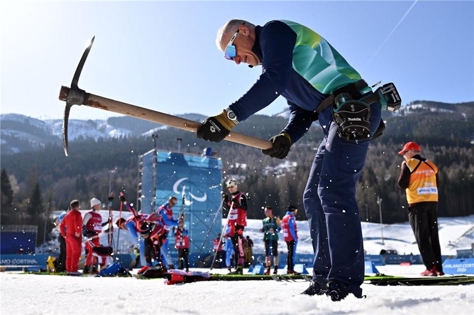 Ein Helfer präpariert die Strecke in Tesero. Martin Schutt/dpa