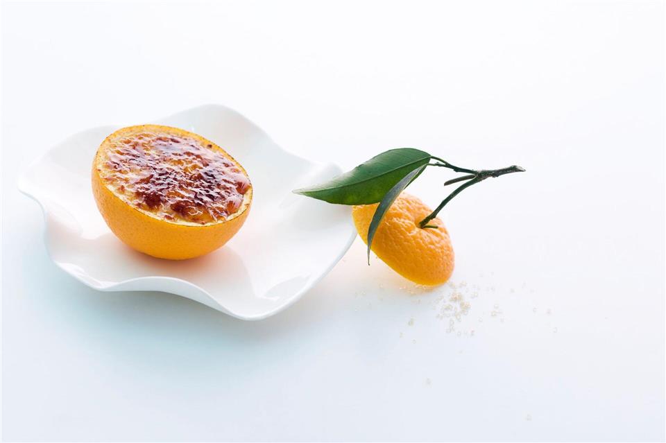Ein Hingucker: Der gebrannte Orangen-Gewürz-Joghurt wird bei Johann Lafer in der ausgehöhlten Orangenhälfte serviert.Michael Wissing/Office Johann Lafer/dpa-tmn