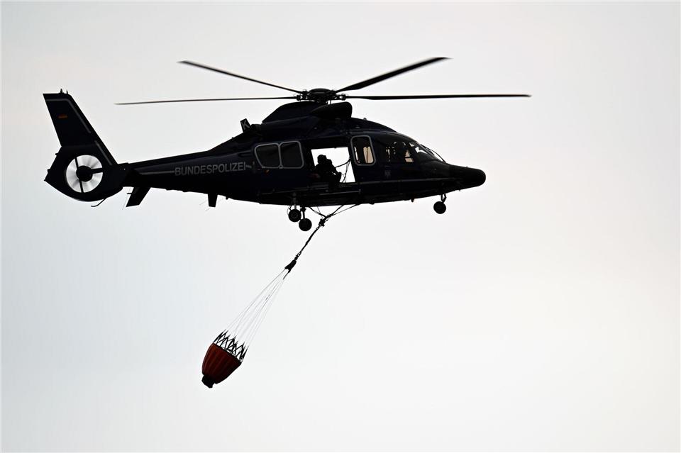 Ein Hubschrauber der Polizei fliegt über Kleinhau.Federico Gambarini/dpa