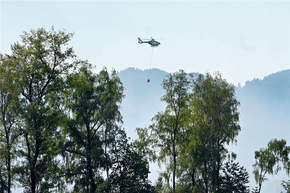 Ein Hubschrauber mit Löschwasser aus dem Chiemsee flog zu dem Brand.Uwe Lein/dpa