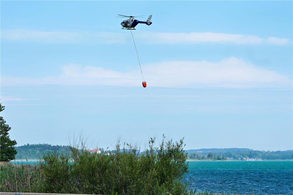 Ein Hubschrauber transportierte Löschwasser aus dem Chiemsee.Uwe Lein/dpa