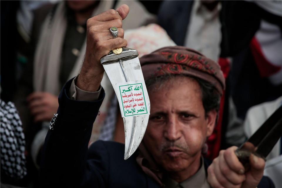 Ein Huthi-Anhänger hebt einen traditionellen jemenitischen Dolch (Jambiya) mit dem Huthi-Slogan (Sarkha), der übersetzt „Allah ist der Größte, Tod für Amerika, Tod für Israel, Fluch über die Juden, Sieg für den Islam“ bedeutet, während einer Demonstration in Sanaa.Osamah Yahya/dpa