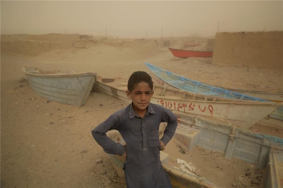 Ein Junge im Iran steht vor alten Booten, wo einst ein See war.Mohammad Dehdast/dpa