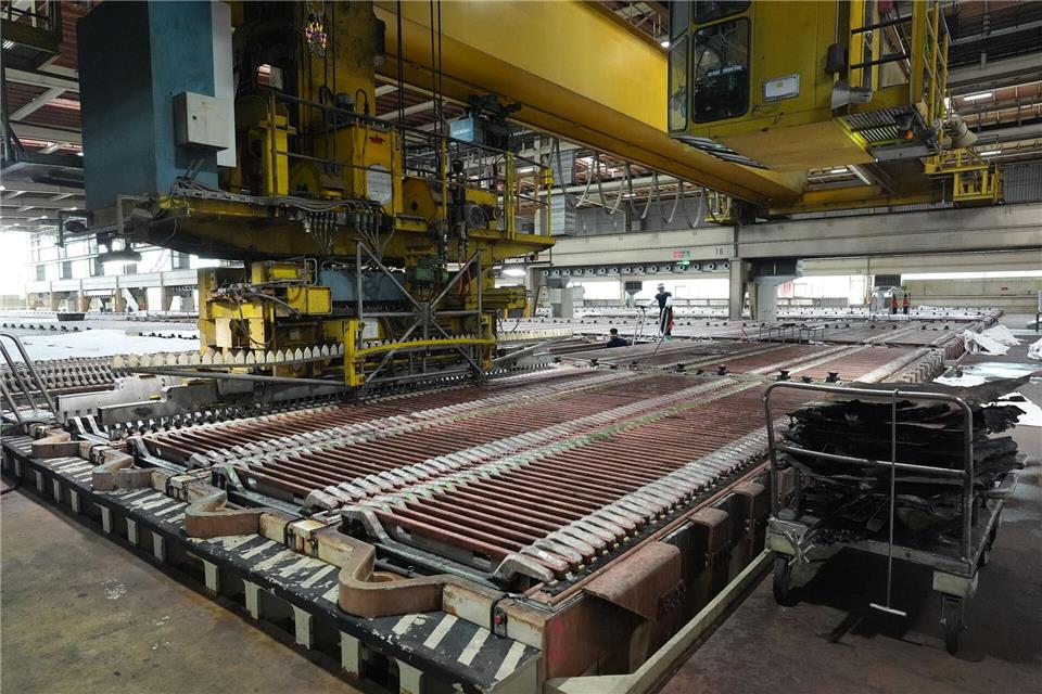 Ein Kran bewegt sich im Hamburger Aurubis-Werk über die sogenannten Elektrolysebecken. Die Elektrolyse ist der letzte Schritt in der Kupferraffination. (Archivbild) Marcus Brandt/dpa