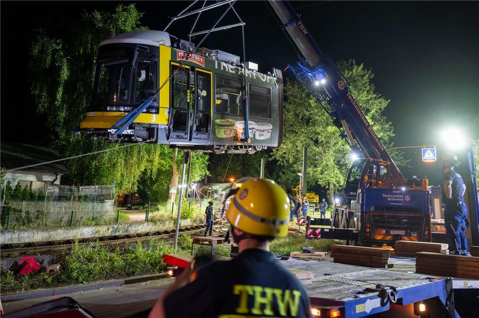 Ein Kran hebt die Straßenbahn aus dem Gleis.Christophe Gateau/dpa