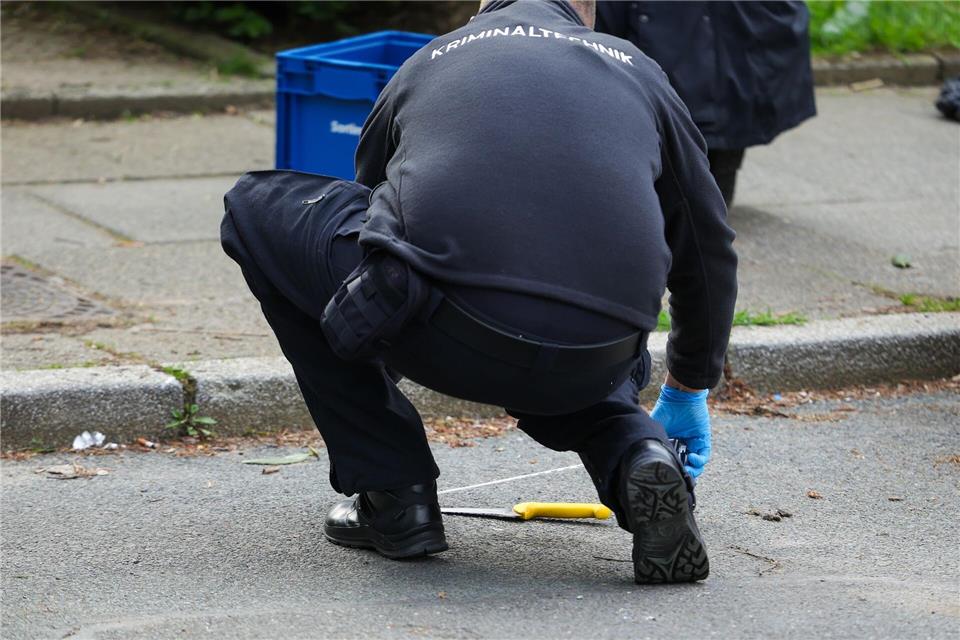Ein Kriminaltechniker untersucht ein Messer am Tatort.Christoph Reichwein/dpa