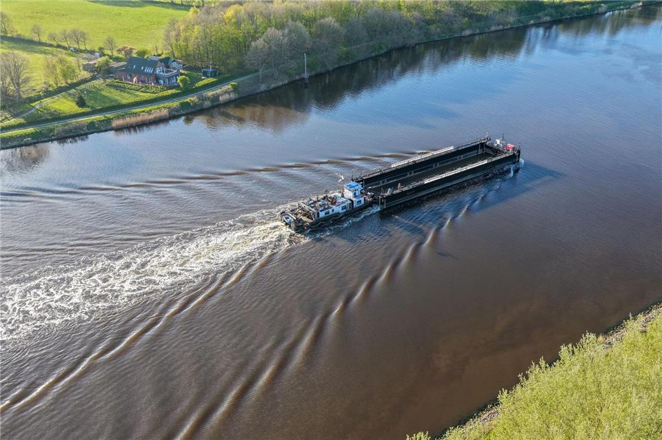 Ein Lastkahn, geschoben von dem Schubschiff „Hans“ fährt auf dem Nord-Ostsee-Kanal bei Hohenhörn. Vor fast einem Monat ist der Buckelwal vor der Insel Poel bei Wismar gestrandet. Diese Woche soll Schiffstechnik den Abtransport des Tiers ermöglichen. Bodo Marks/dpa