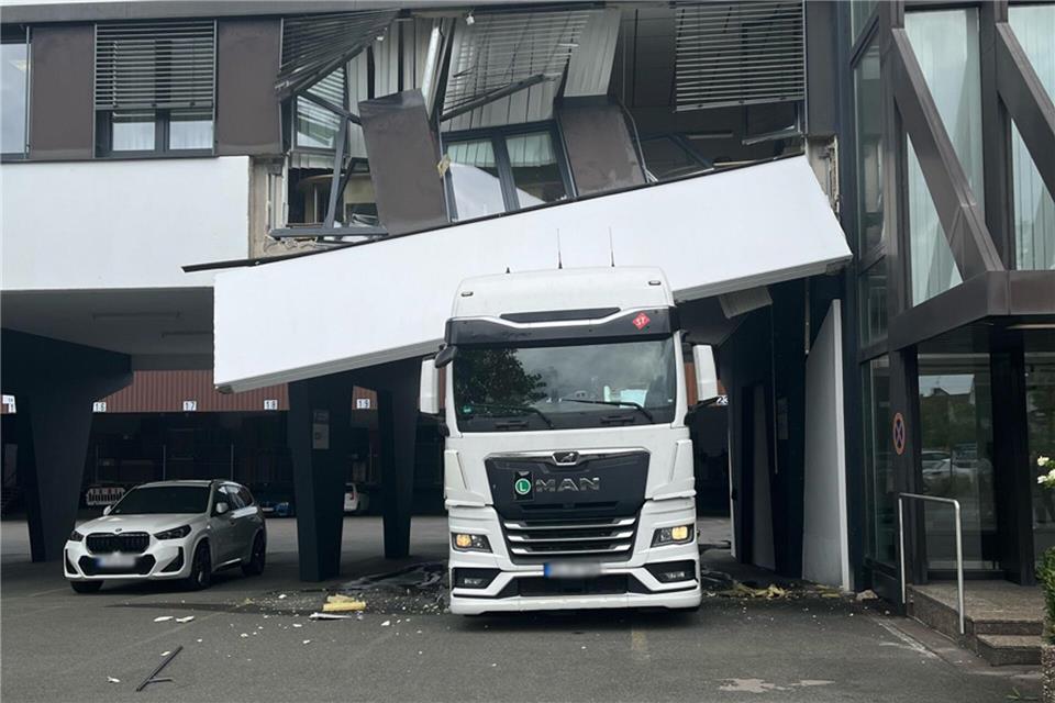 Ein Lastwagen steckt unter einer Hausfassade fest. Bei der Durchfahrt ist der Lkw in Detmold hängengeblieben. (Handoutbild)Polizei Kreis Lippe/dpa