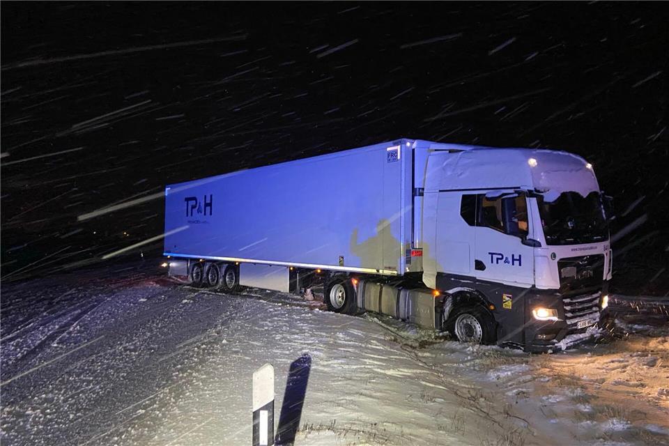 Ein Lkw ist in Rheinland-Pfalz aufgrund der schneeglatten Fahrbahn ins Rutschen gekommen und hat so den Verkehr blockiert. Polizeiinspektion Morbach/dpa