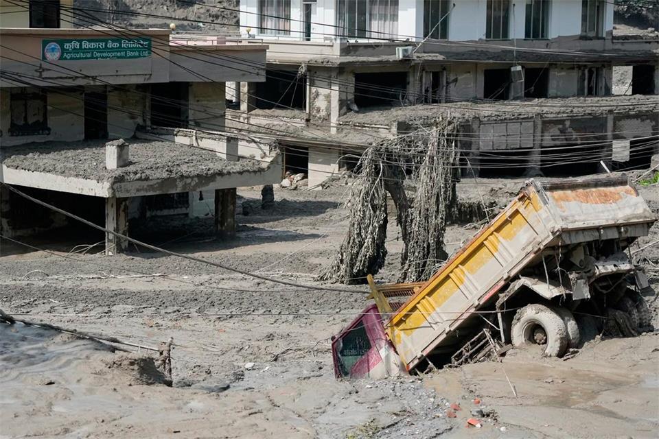 Ein Lkw versinkt in den Schlammmassen.Niranjan Shrestha/AP/dpa