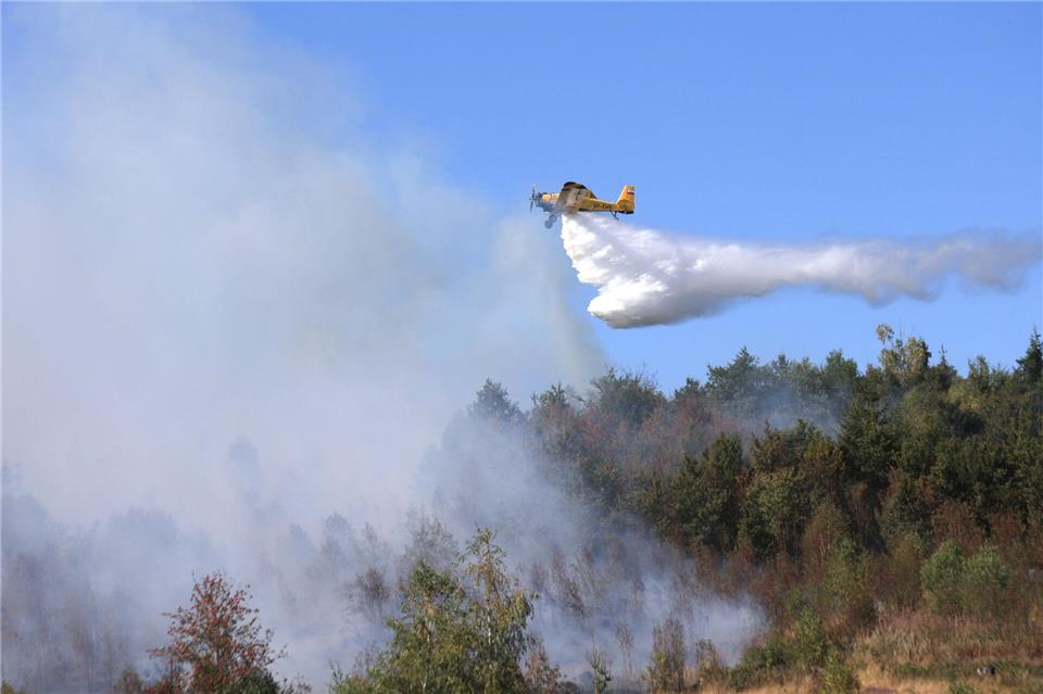 Ein Löschflugzeug unterstützt die Einsatzkräfte bei den Löscharbeiten im Harz.Matthias Bein/dpa
