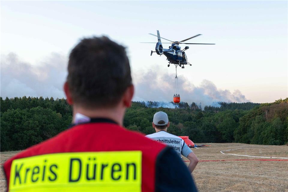 Ein Löschhubschrauber bekämpft am Donnerstagabend die Flammen des Waldbrandes Nahe Hürtgenwald.Jan Ohmen/dpa