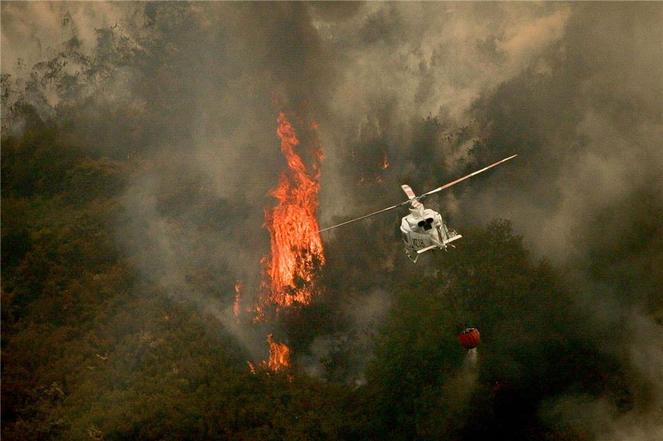 Ein Löschhubschrauber wirft Wasser über einem Feuer in der spanischen Provinz Ourense ab.Adrián Irago/EUROPA PRESS/dpa